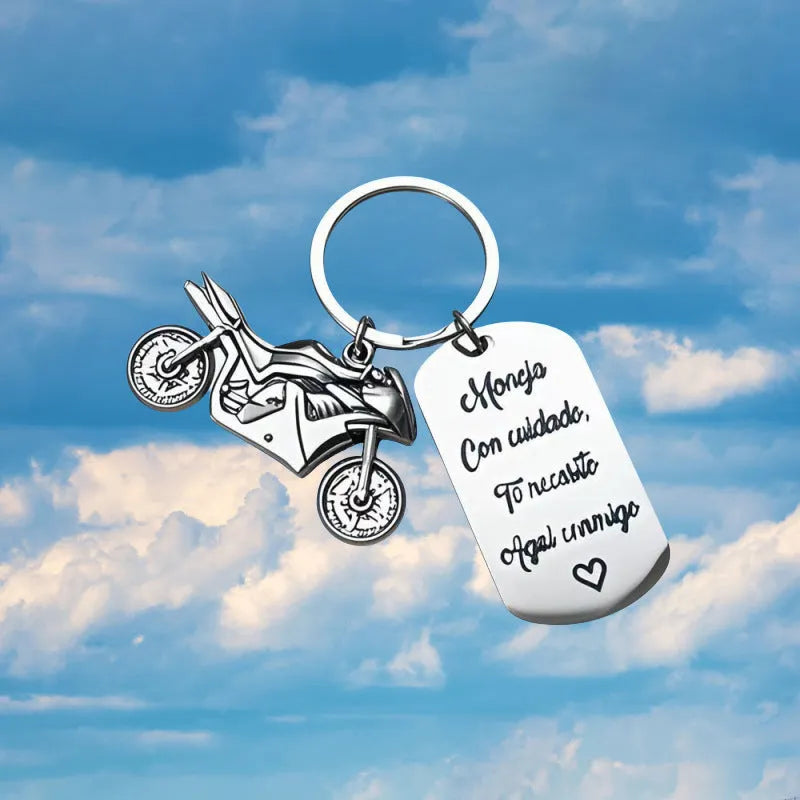 Stainless steel motorcycle keychain with inspirational charm on a flannel bag.