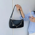 Women's butterfly chain underarm bag in black colour showing crossbody strap and three-dimensional pocket