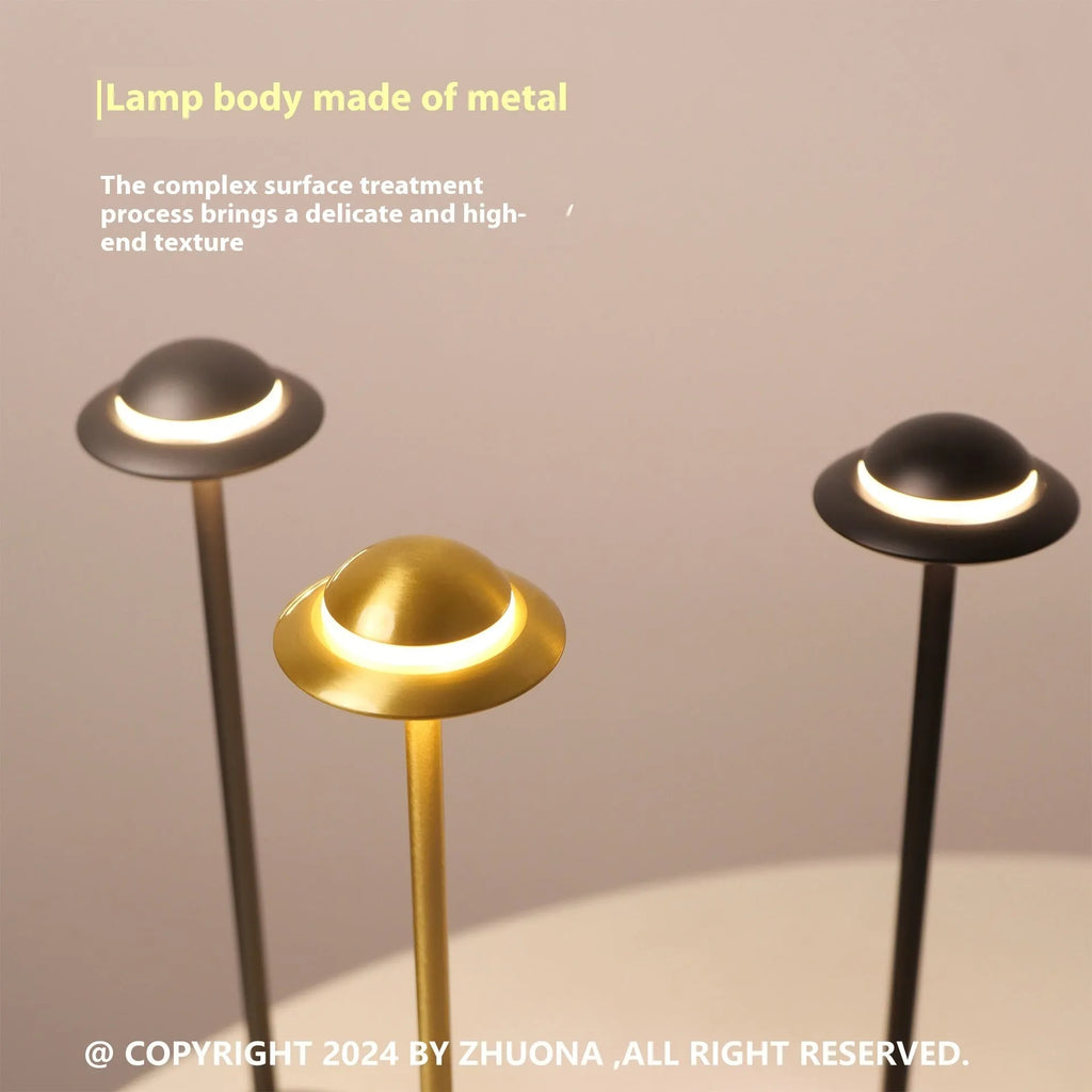 Gold UFO-shaped metal desk lamp with touch controls on creative rechargeable LED lamp