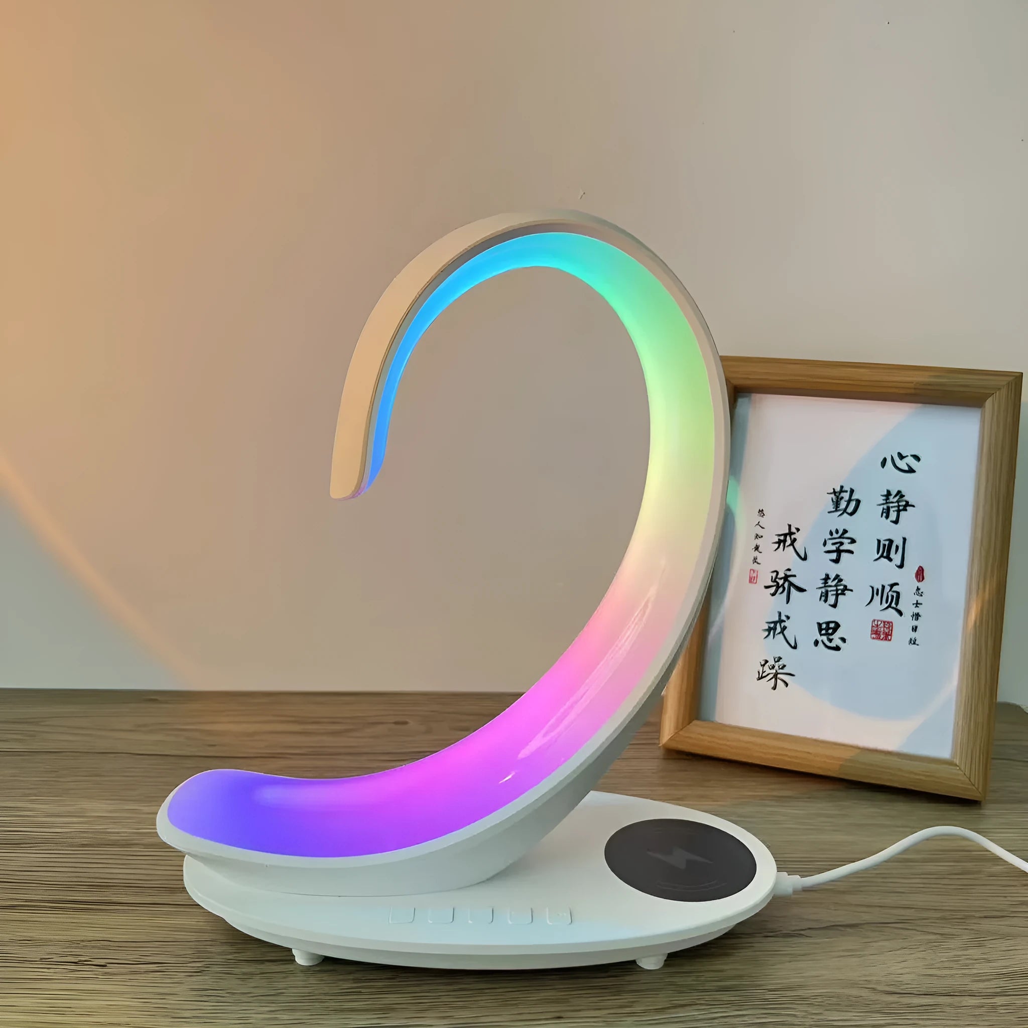 White swan-shaped desk lamp with wireless charging base and Bluetooth speaker emitting colourful light.