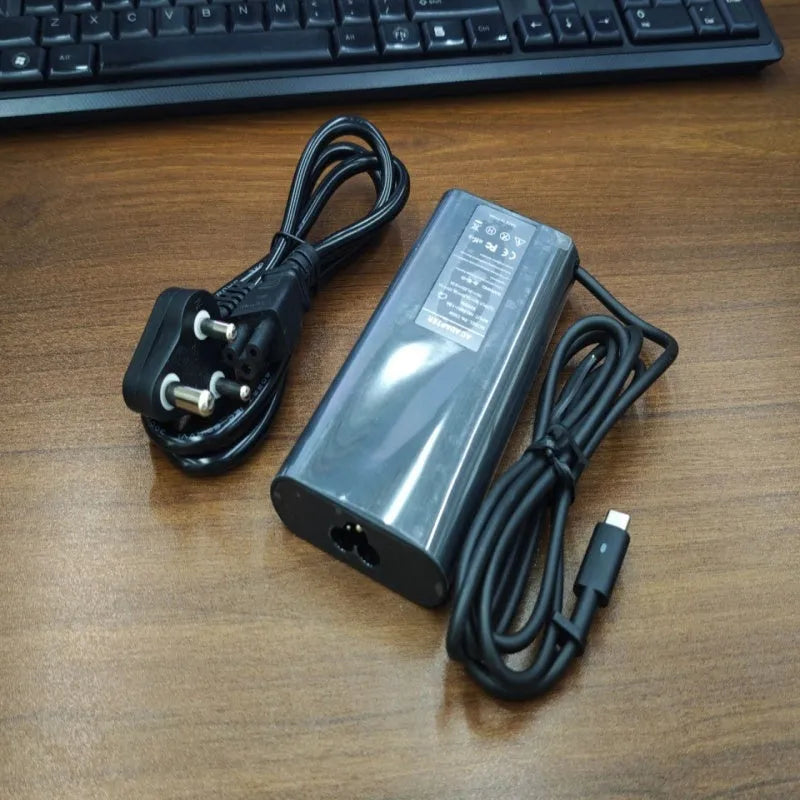 Black 65W Type-C laptop power adapter with multiple international plug heads on a white background.