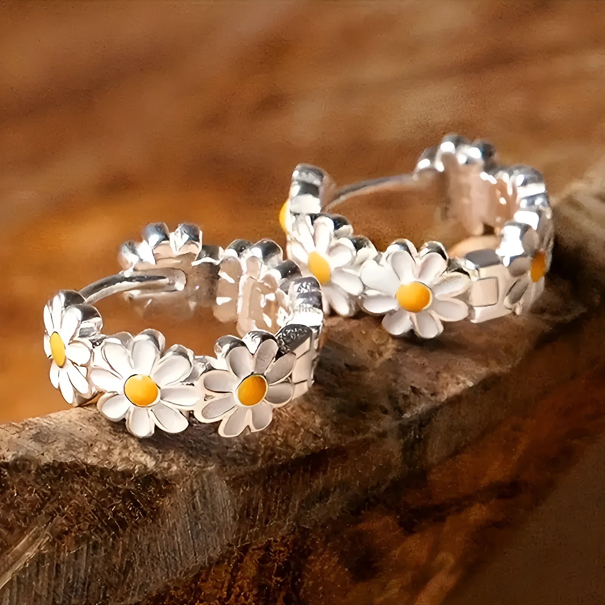 A pair of white daisy flower ring earrings with a gemstone inlay, shown on a model or display.