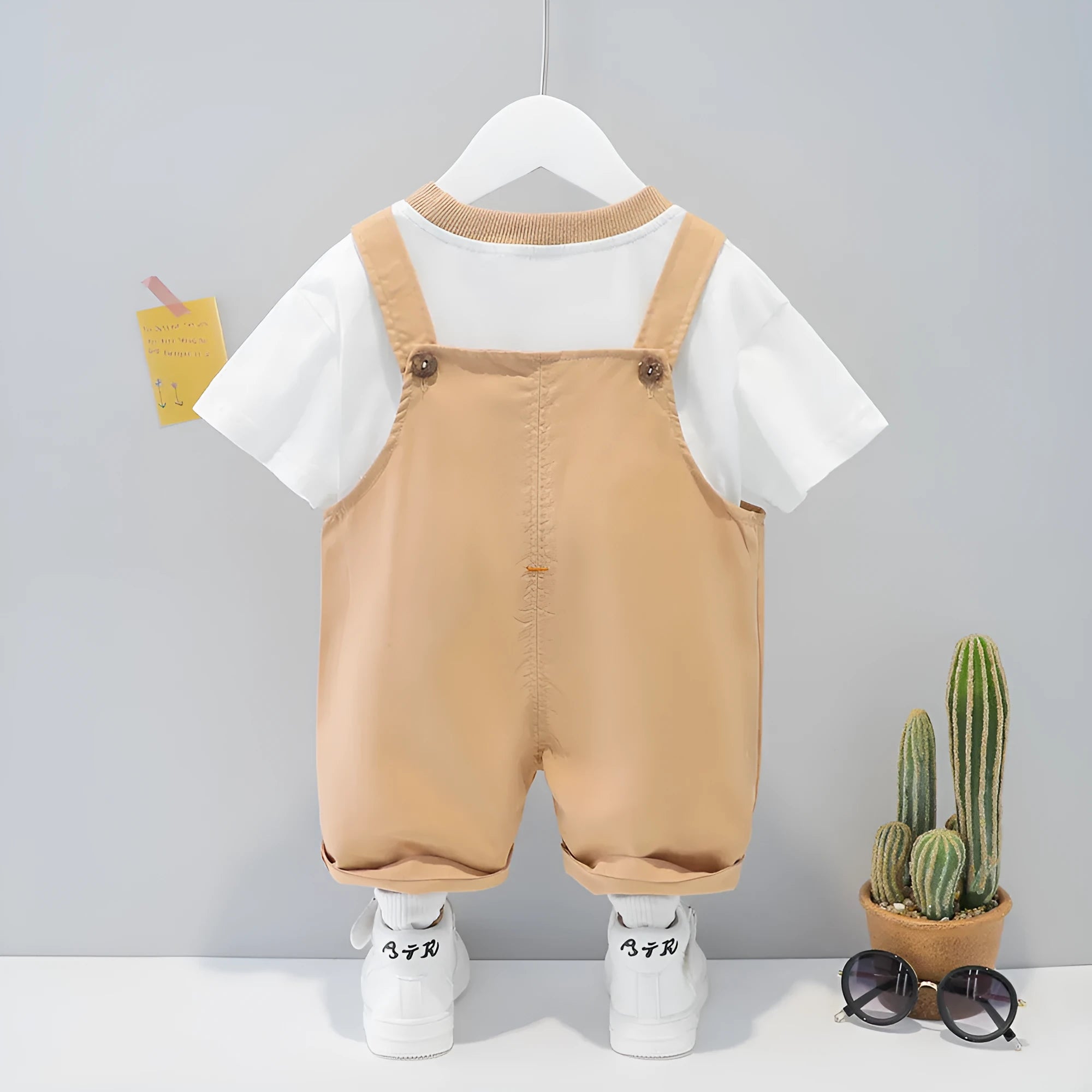 Yellow cotton baby summer overalls with cartoon design and openable straps on infant