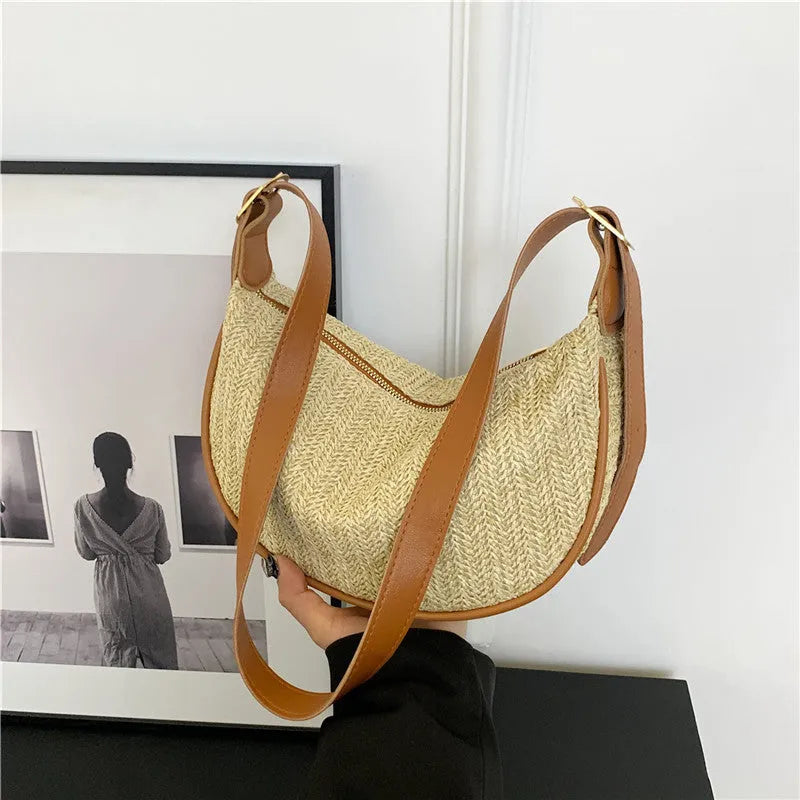 Women's straw woven crossbody bag showing texture and internal phone and file compartments.