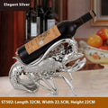 Metallic rose gold lobster-shaped resin ornament holding a wine bottle.
