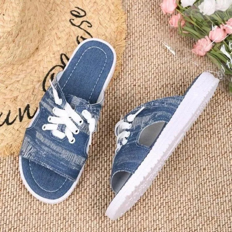 Blue women's flat canvas Roman style slippers with cloth upper and rubber sole.