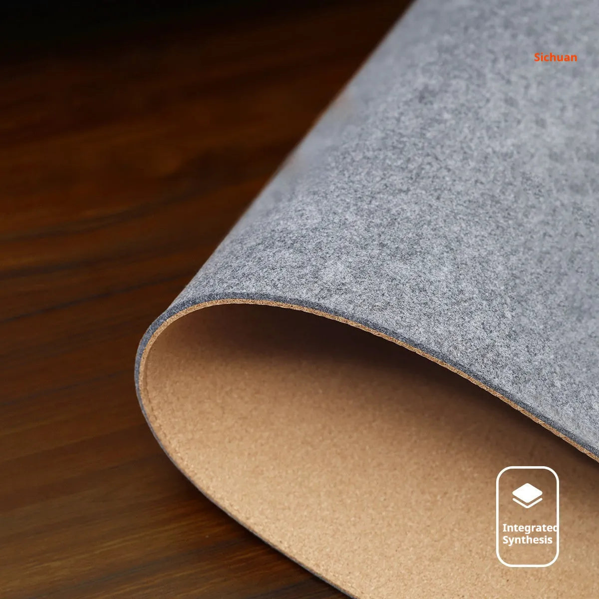 Simple grey felt and cork desk mat in an oversized rectangle shape on a wooden desk.