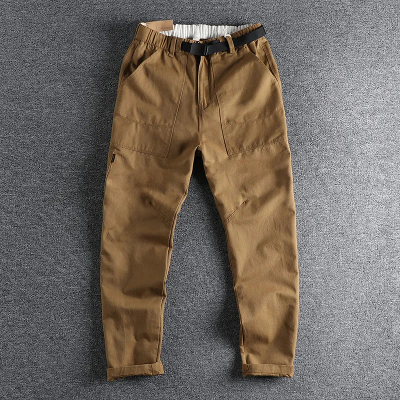 Men's khaki cotton work trousers with an N I buckle belt on a mid waist.