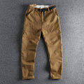 Men's khaki cotton work trousers with an N I buckle belt on a mid waist.