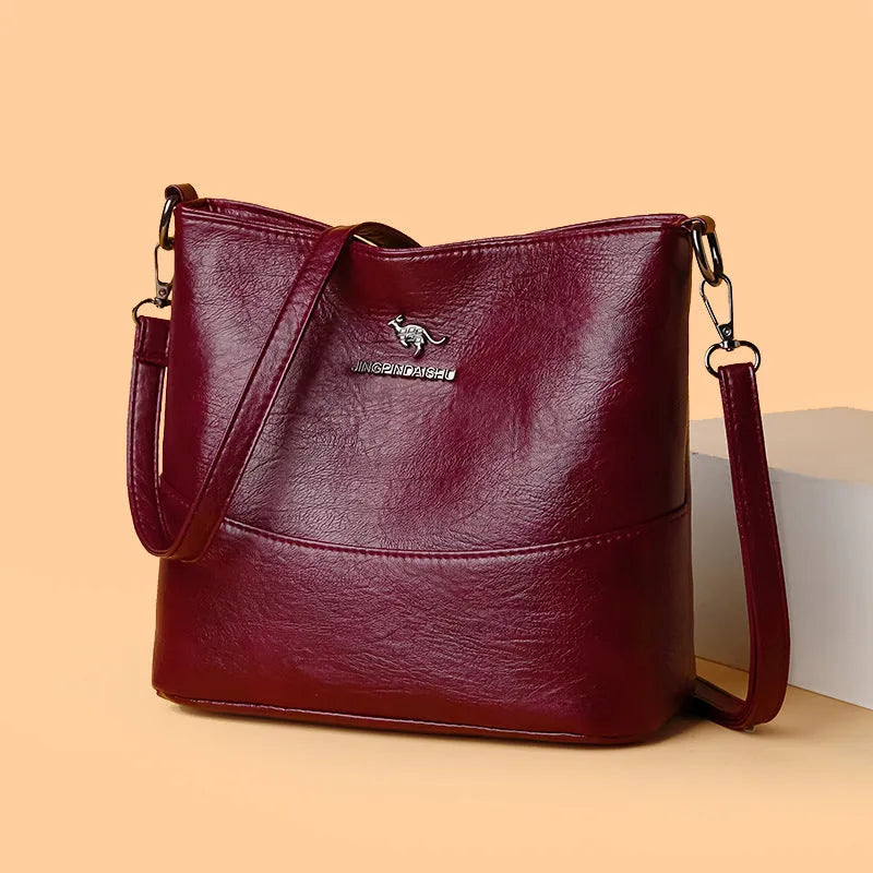 Women's black bucket-style leather shoulder bag with sewing line detailing and shoulder strap