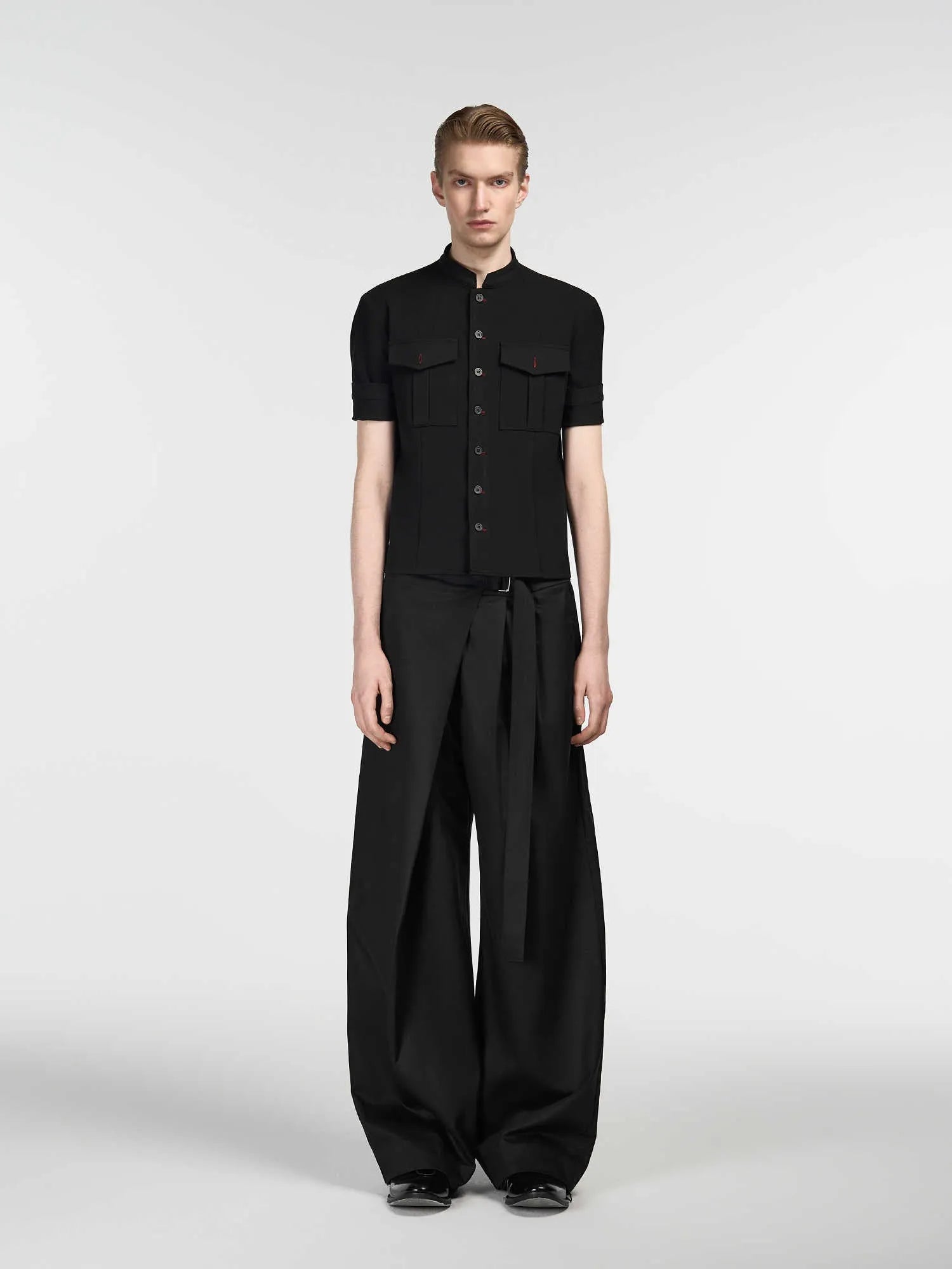 Black straight-leg trousers with a single pleat and adjustable waistband on a plain background.