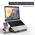 Black ABS plastic laptop bracket on a wooden desk next to a laptop.