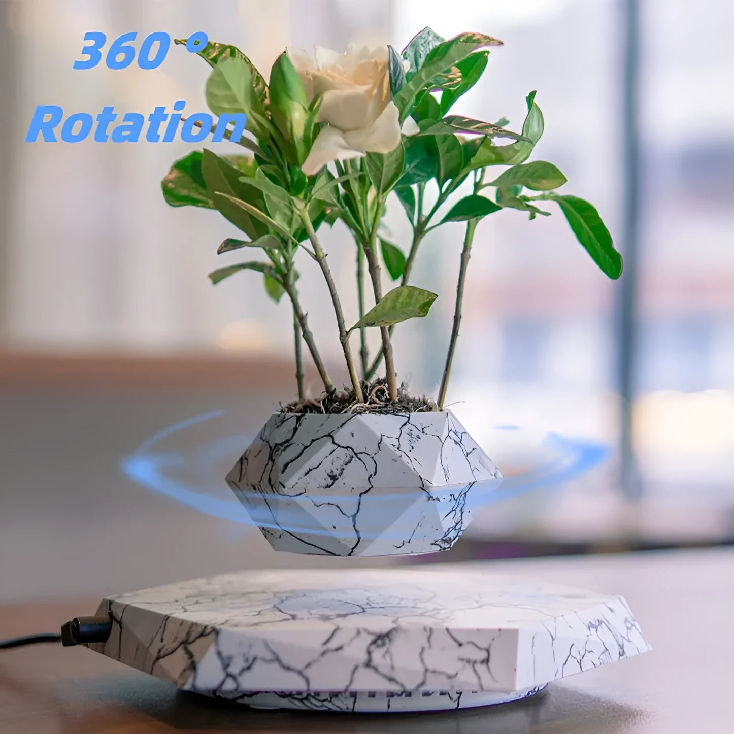 Marble-coloured levitating plant pot floating above magnetic base with small indoor plant