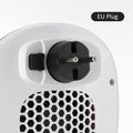 White ceramic portable electric heater with remote control on a table.