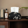 Chinese brocade fabric tissue box cover with embroidered white plum pattern, shown with and without a pearl buckle clasp