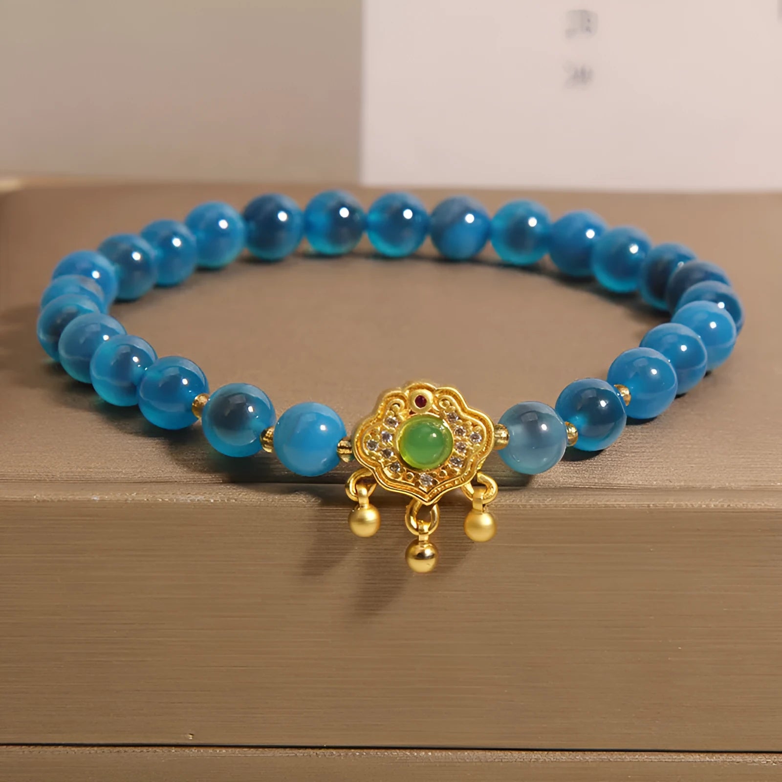 Blue sugar heart agate and jade safety lock pendant on a women's crystal bracelet with alloy inlay.