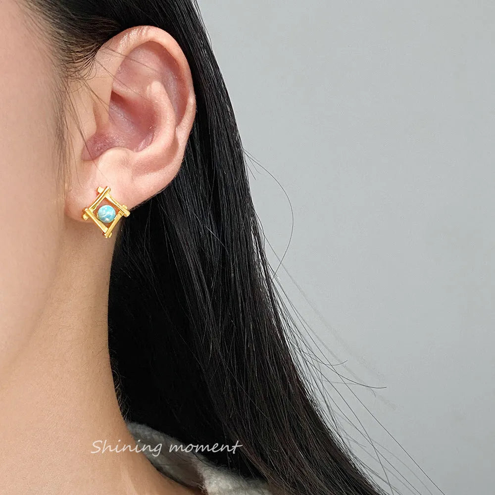 Geometric cross-shaped quadrangle stud earrings in sterling silver, shown in both silver and gold-plated finishes.
