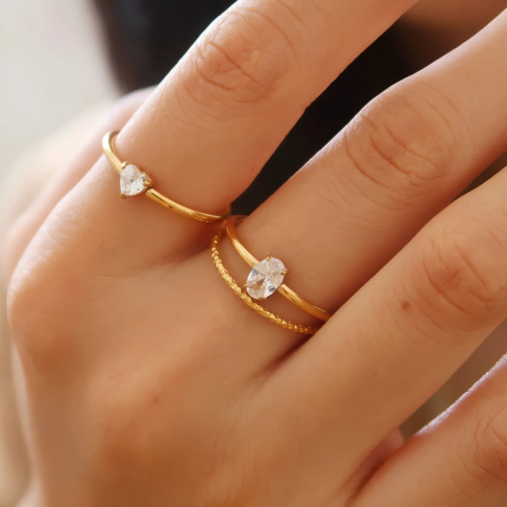 Golden stainless steel ring showing heart shape and oval style options for women in multiple sizes