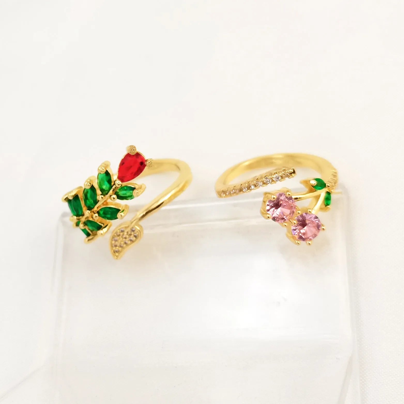Copper open ring with a geometric gold zircon leaf design on a model's hand.