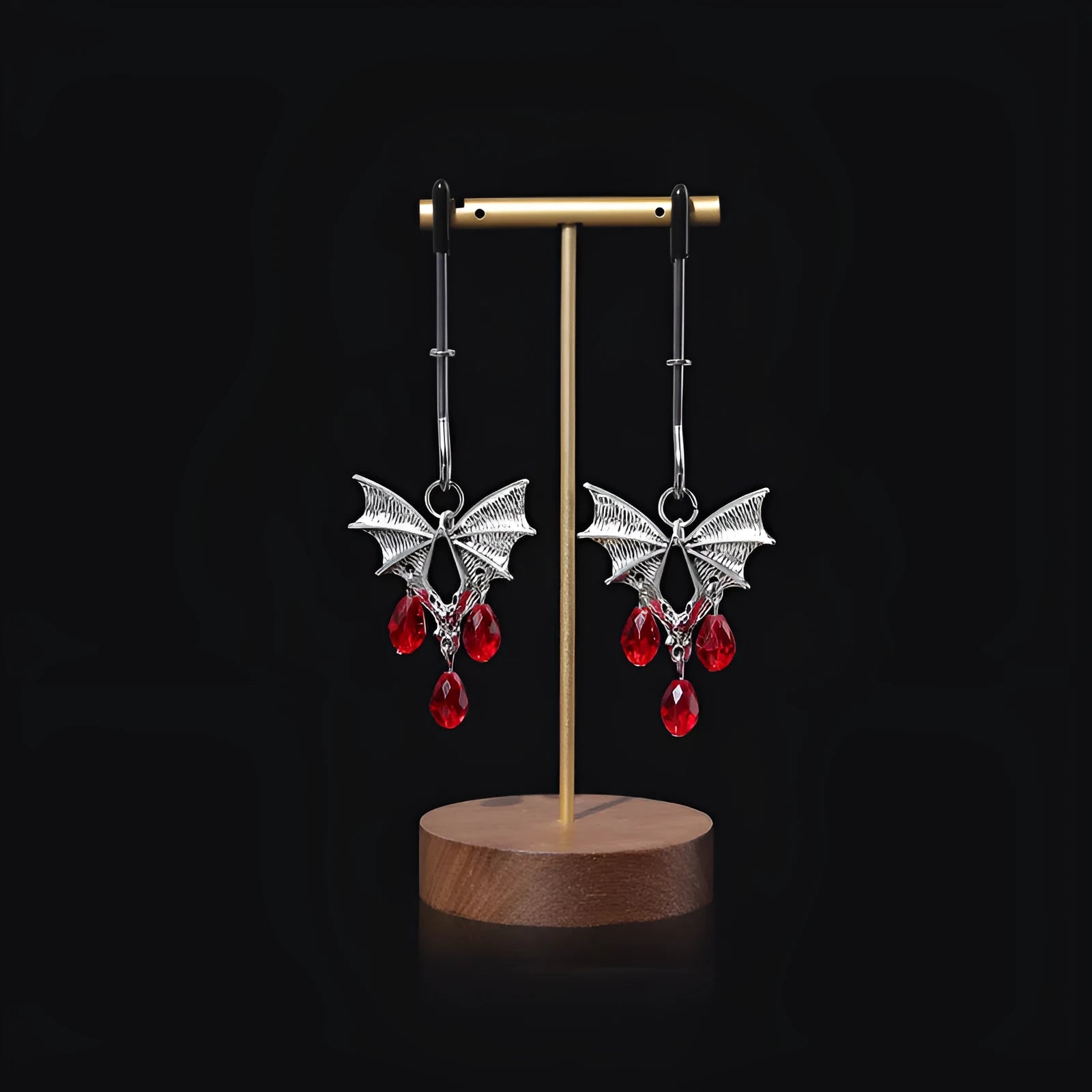 Silver alloy bat-shaped nipple clamp with ruby details and adjustable rubber-padded mechanism.