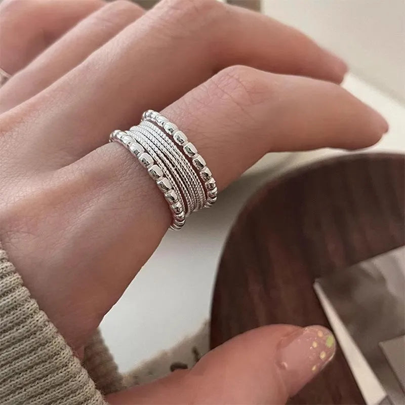 Adjustable opening copper alloy ring with geometric shape and woven twisted multilayer design