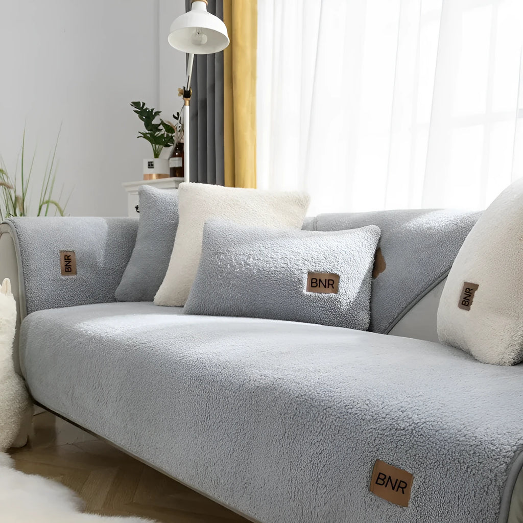 Lambswool sofa slipcover in a solid blue colour, shown on a sofa.