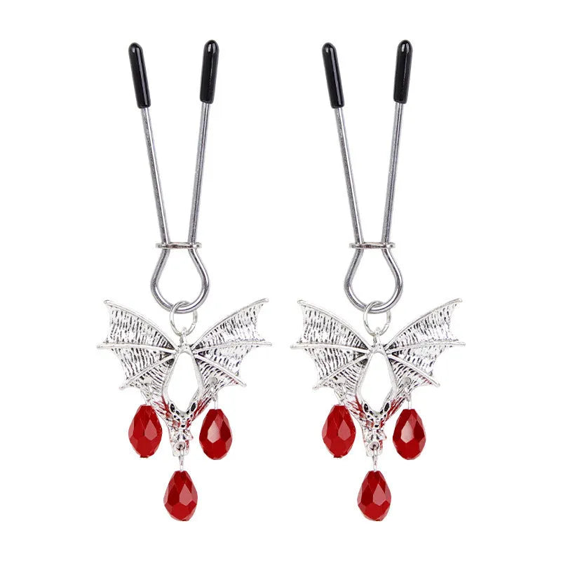 Silver alloy bat-shaped nipple clamp with ruby details and adjustable rubber-padded mechanism.