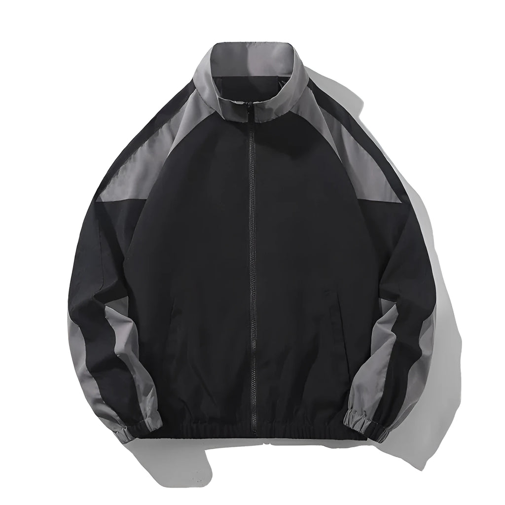 Man wearing a black casual jacket with contrast stitching and side seam pockets.