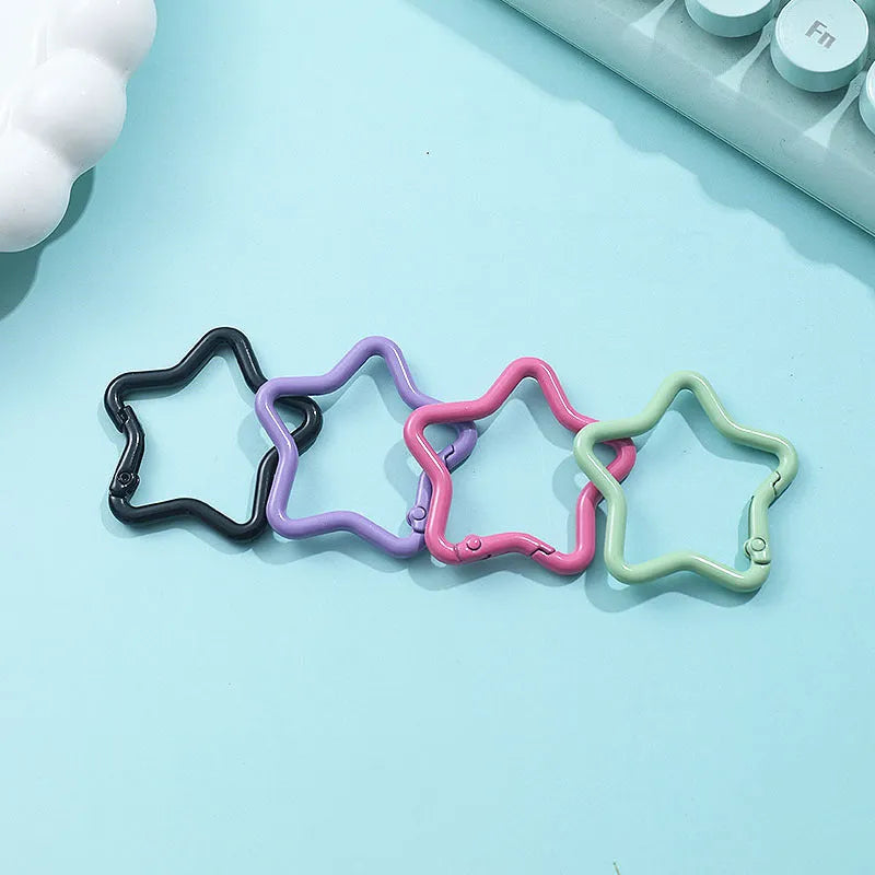Zinc alloy five-pointed star keychain charm in assorted colours on a key ring.