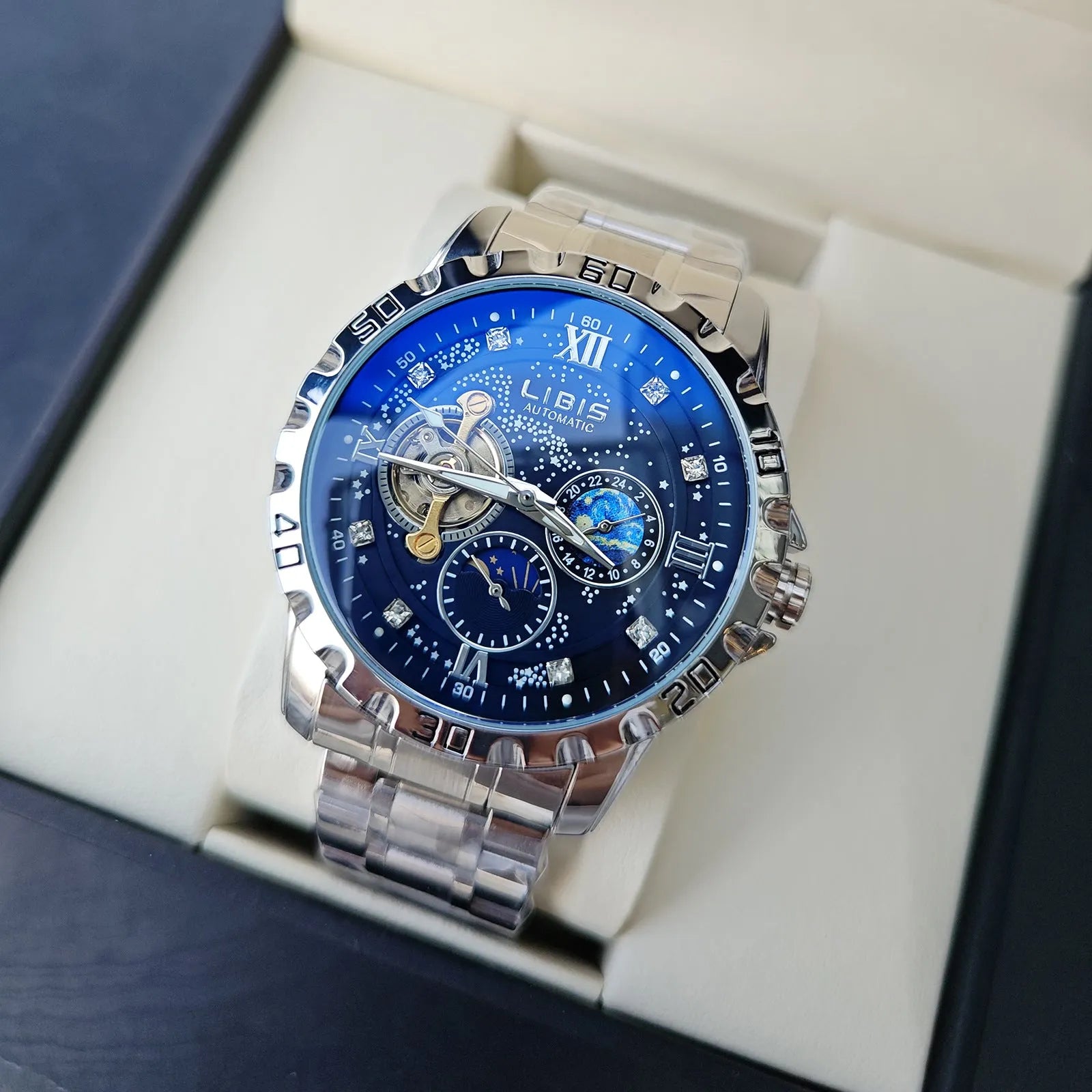 Men's silver automatic watch with black starry dial and leather strap showing luminous hands