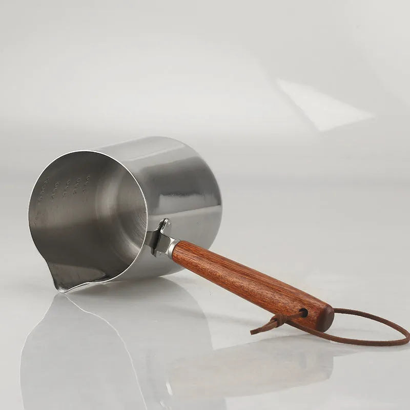 Stainless steel coffee cup with wooden handle showing measurement scale marks