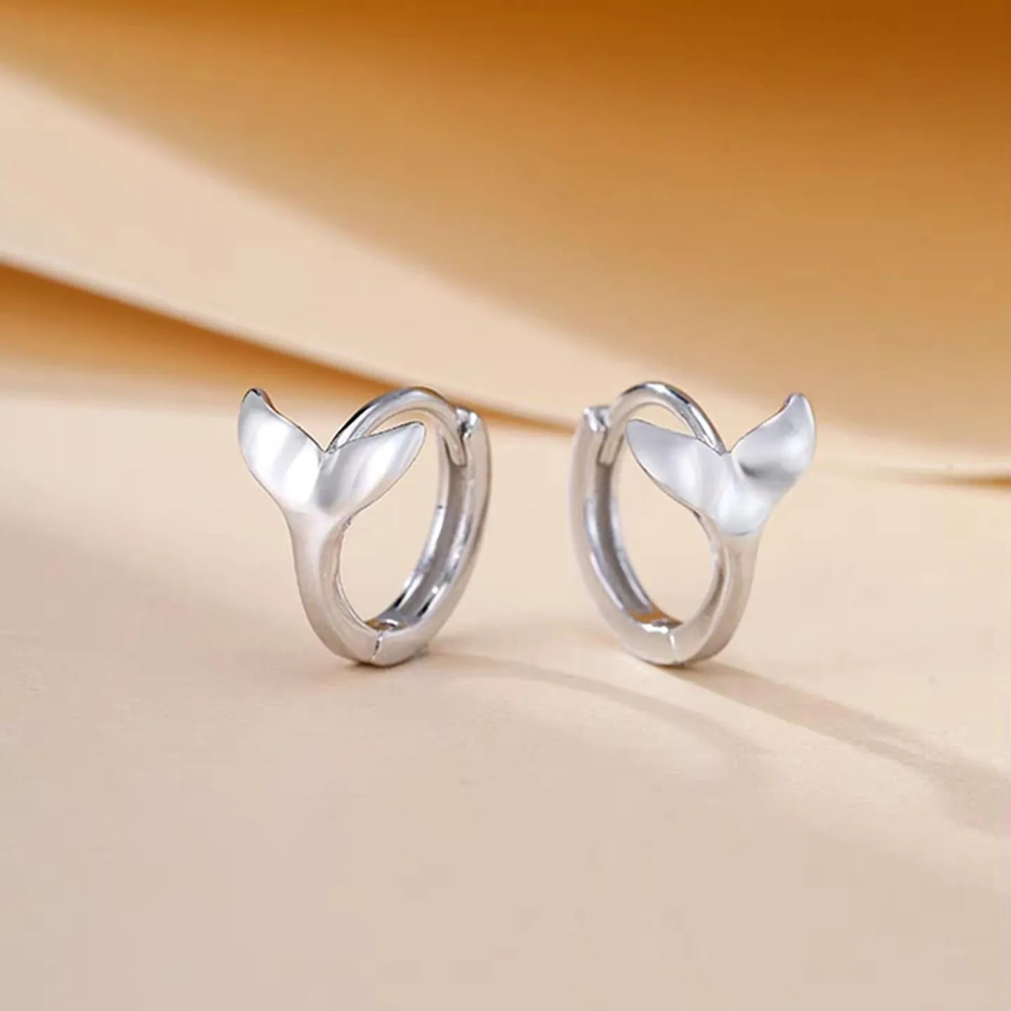 Women's fishtail design earrings with electroplated finish in white gold or yellow gold colour