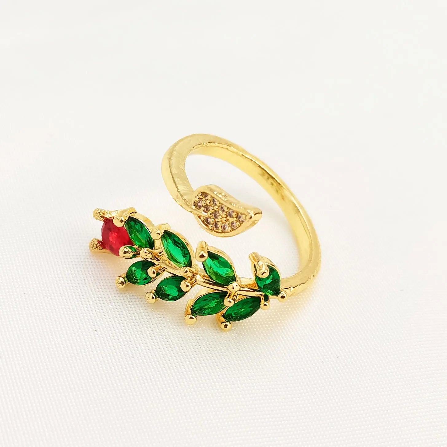 Copper open ring with a geometric gold zircon leaf design on a model's hand.
