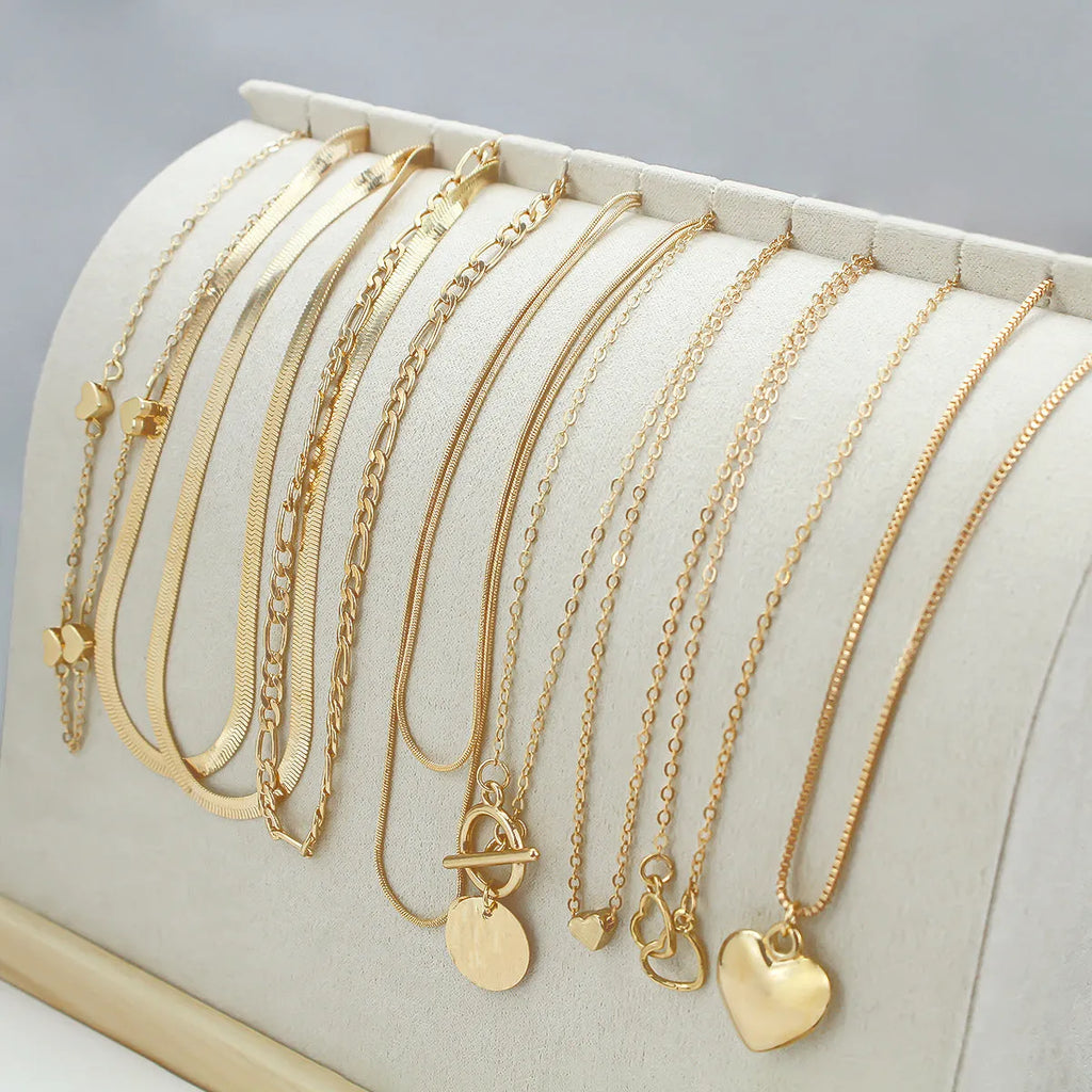 10 gold necklaces with snake bone chains and alloy pendants arranged in jewellery set