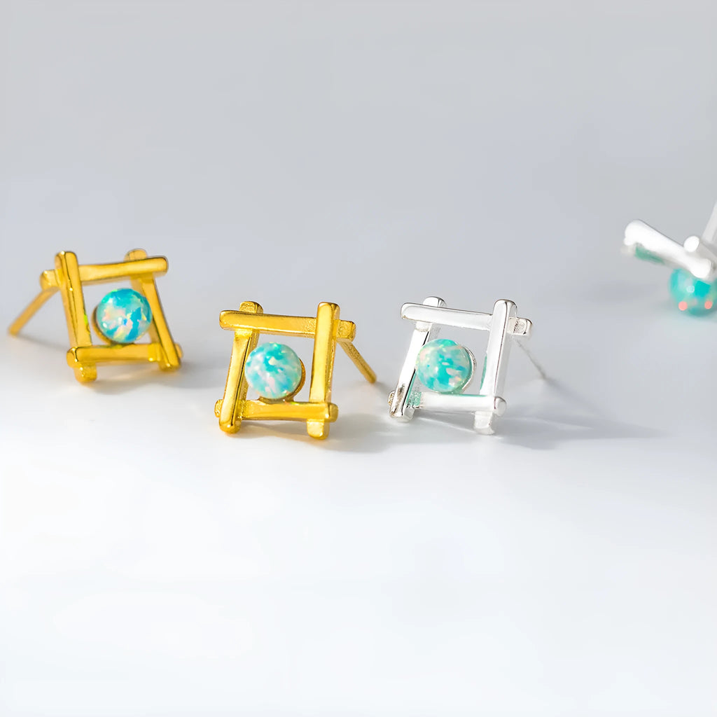 Geometric cross-shaped quadrangle stud earrings in sterling silver, shown in both silver and gold-plated finishes.