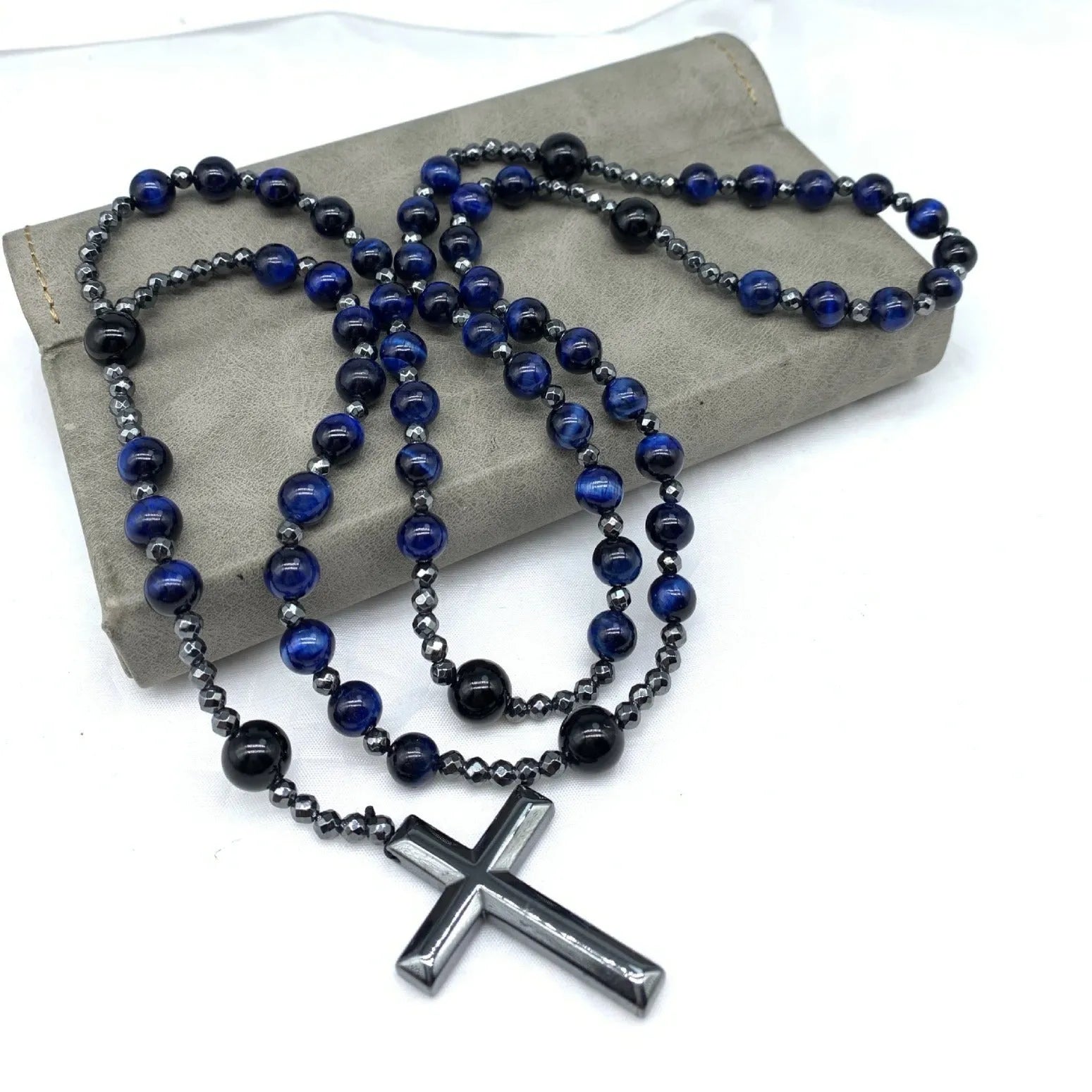 Men's stone necklace with a geometric cross pendant on a ball bead chain, showing the safety lock clasp.