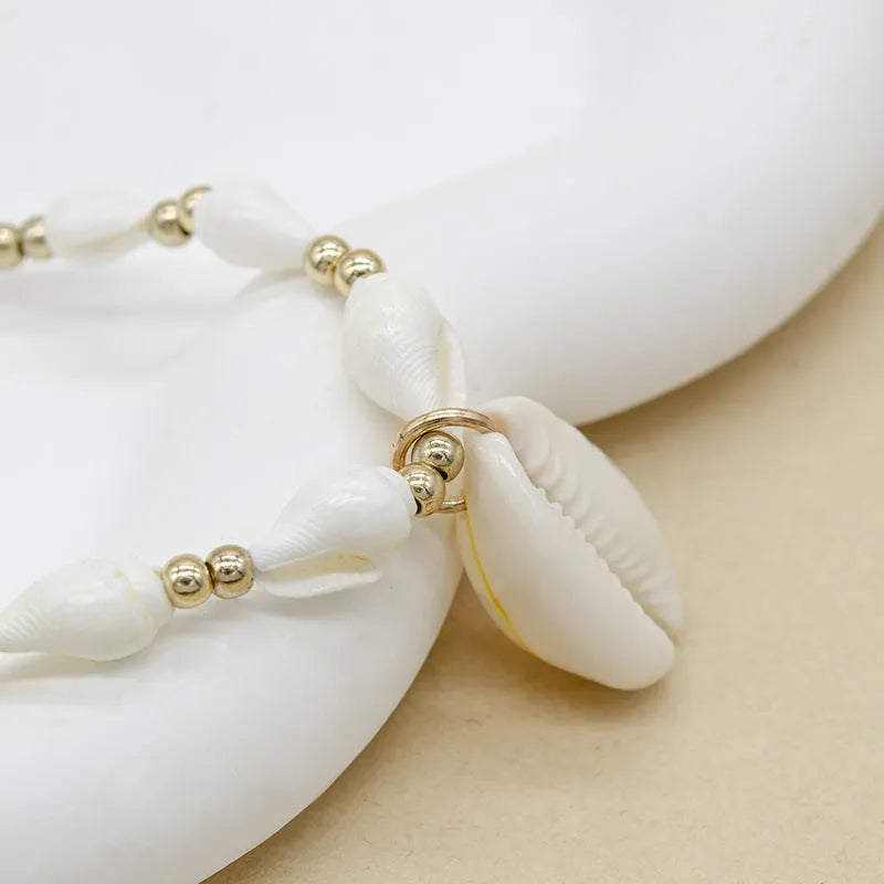 White shell bead necklace with conch pendant and mother-of-pearl detail
