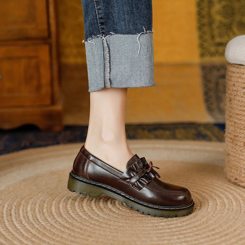 Women's black leather shoes with round toe and chunky flat heel, low-top design.