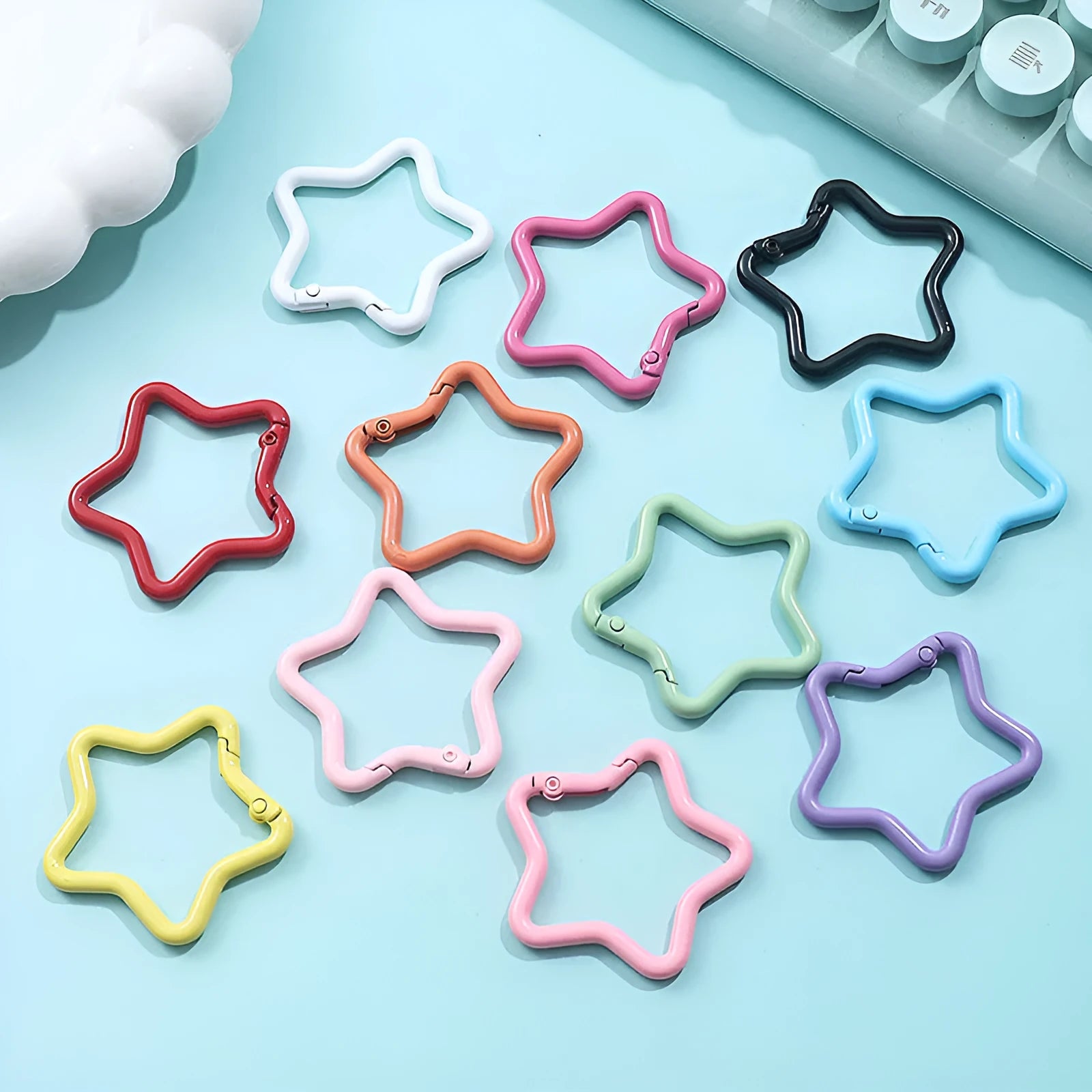 Zinc alloy five-pointed star keychain charm in assorted colours on a key ring.
