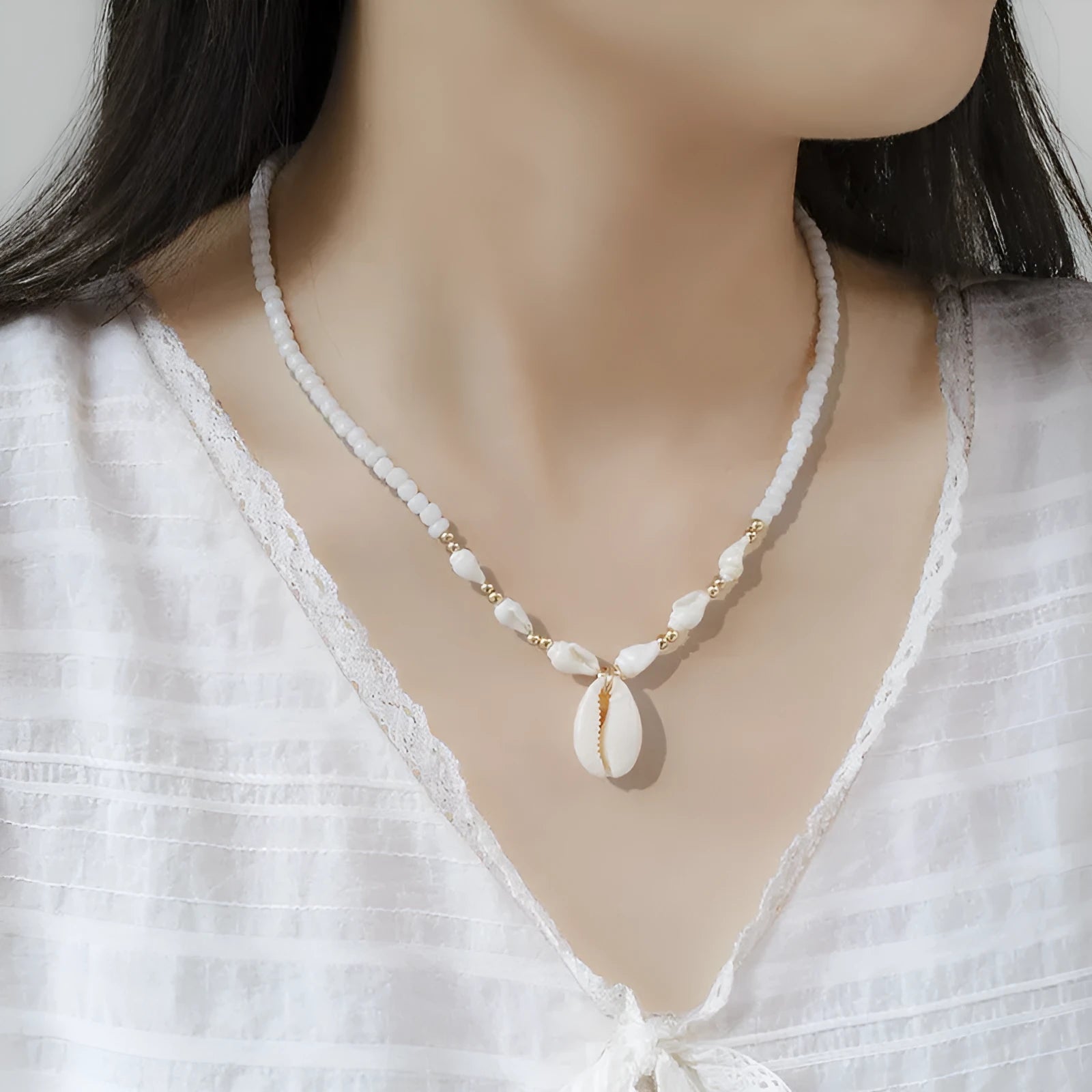 White shell bead necklace with conch pendant and mother-of-pearl detail
