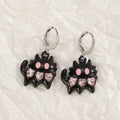 Women's alloy earrings with cross and heart designs in white, black, and silver colour options.