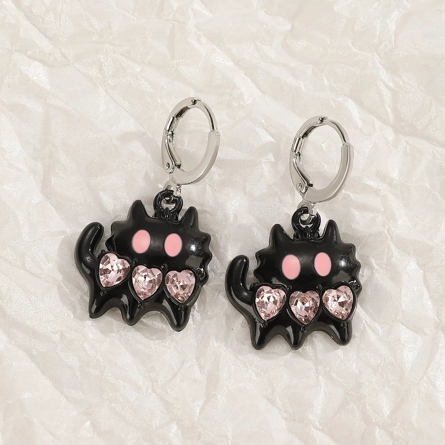 Women's alloy earrings with cross and heart designs in white, black, and silver colour options.