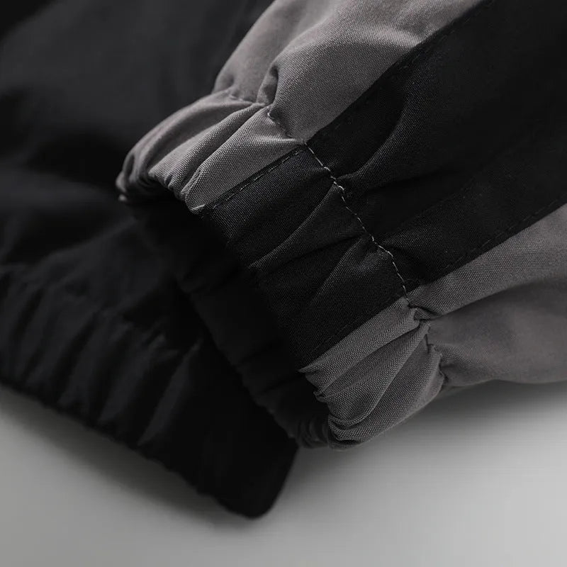 Man wearing a black casual jacket with contrast stitching and side seam pockets.