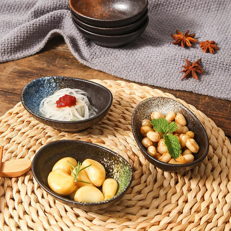 Oval Japanese ceramic sauce dipping bowl with underglaze decorative pattern on simple white background