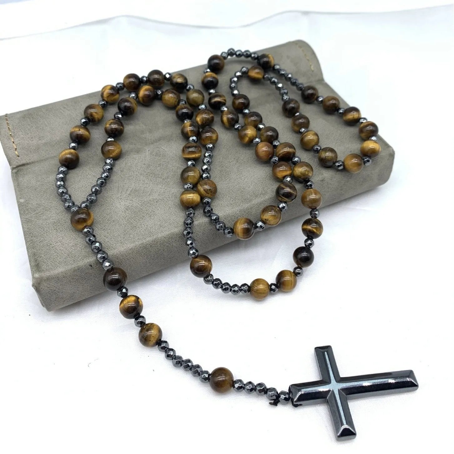 Men's stone necklace with a geometric cross pendant on a ball bead chain, showing the safety lock clasp.