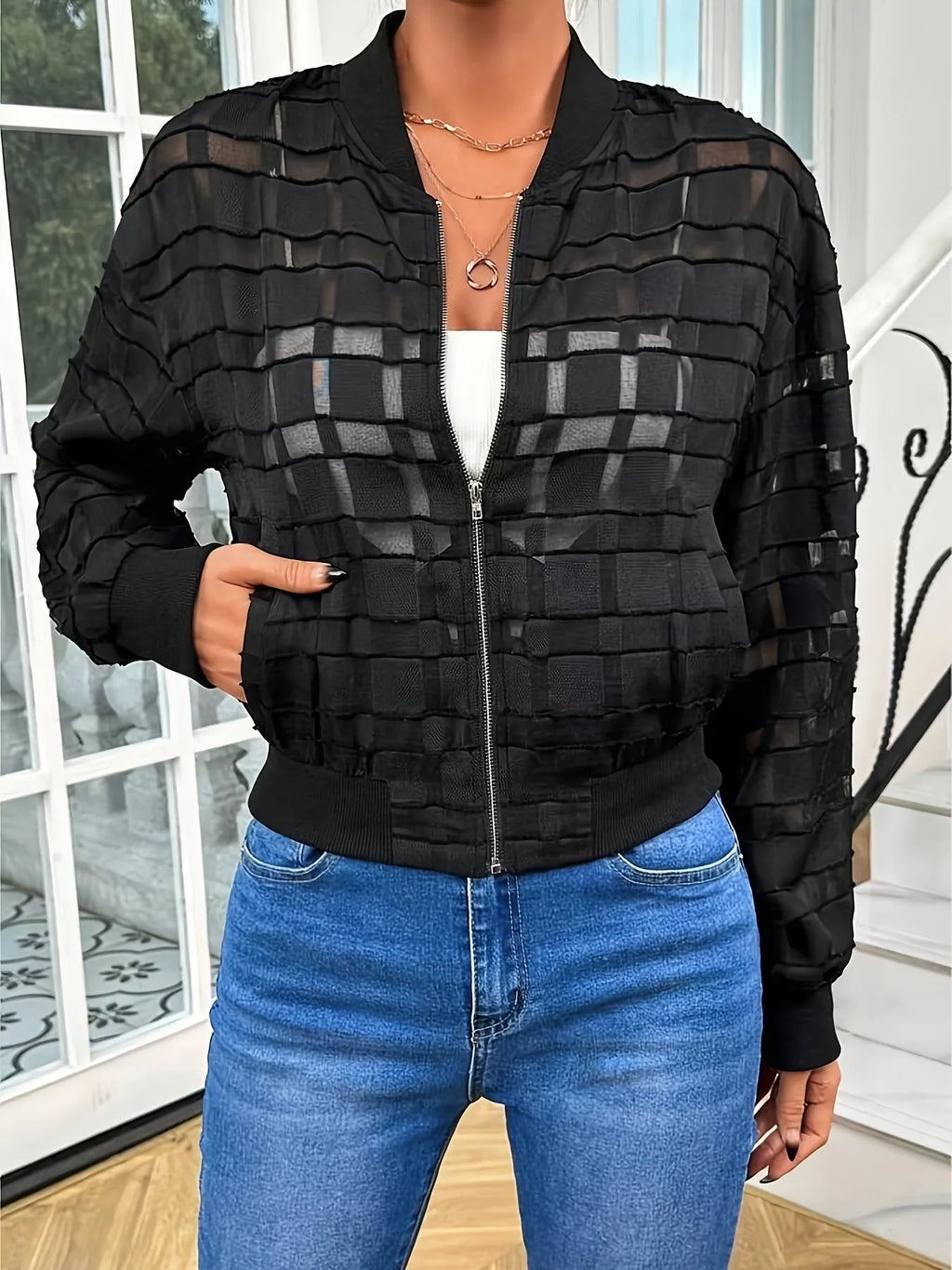 Black semi-transparent women's jacket with geometric pattern, thread zipper, and long sleeves.