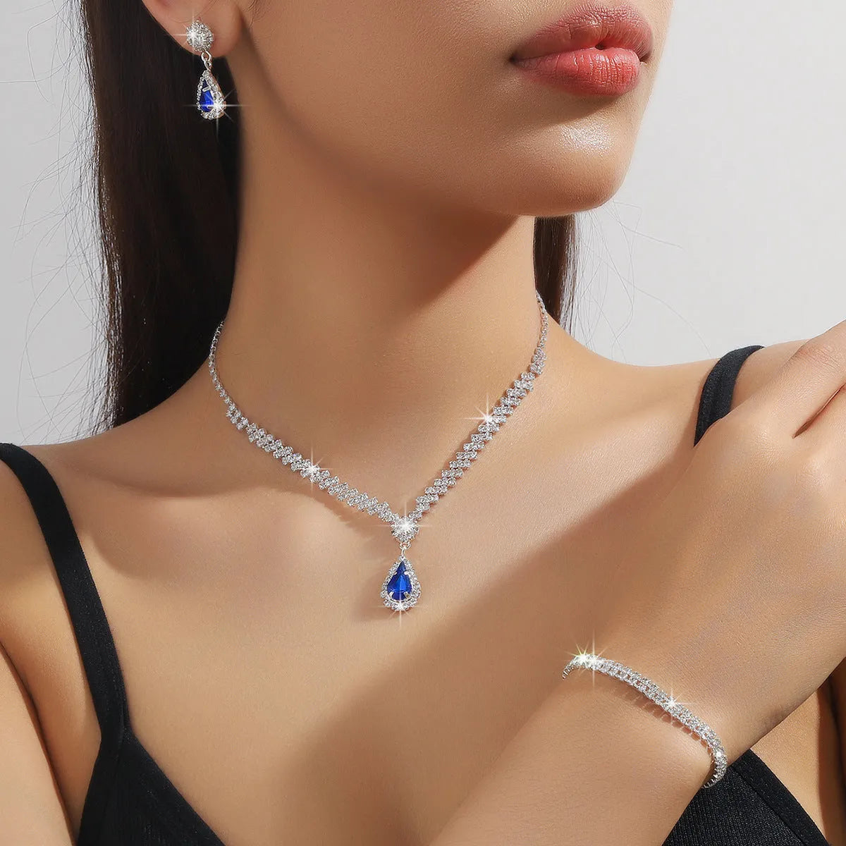 Claw chain rhinestone jewellery set with water drop shapes in a choice of colours, showing necklace, earrings, and optional bracelet.