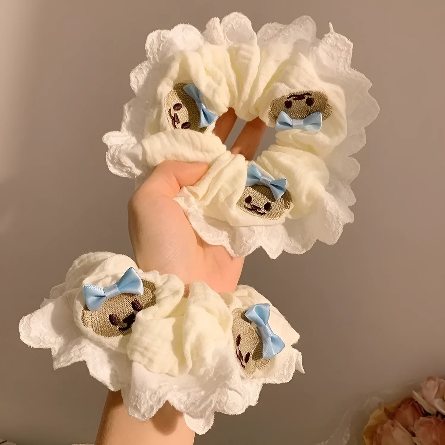 Close-up of a blue cloth hair ring with a bear design and a bowknot.