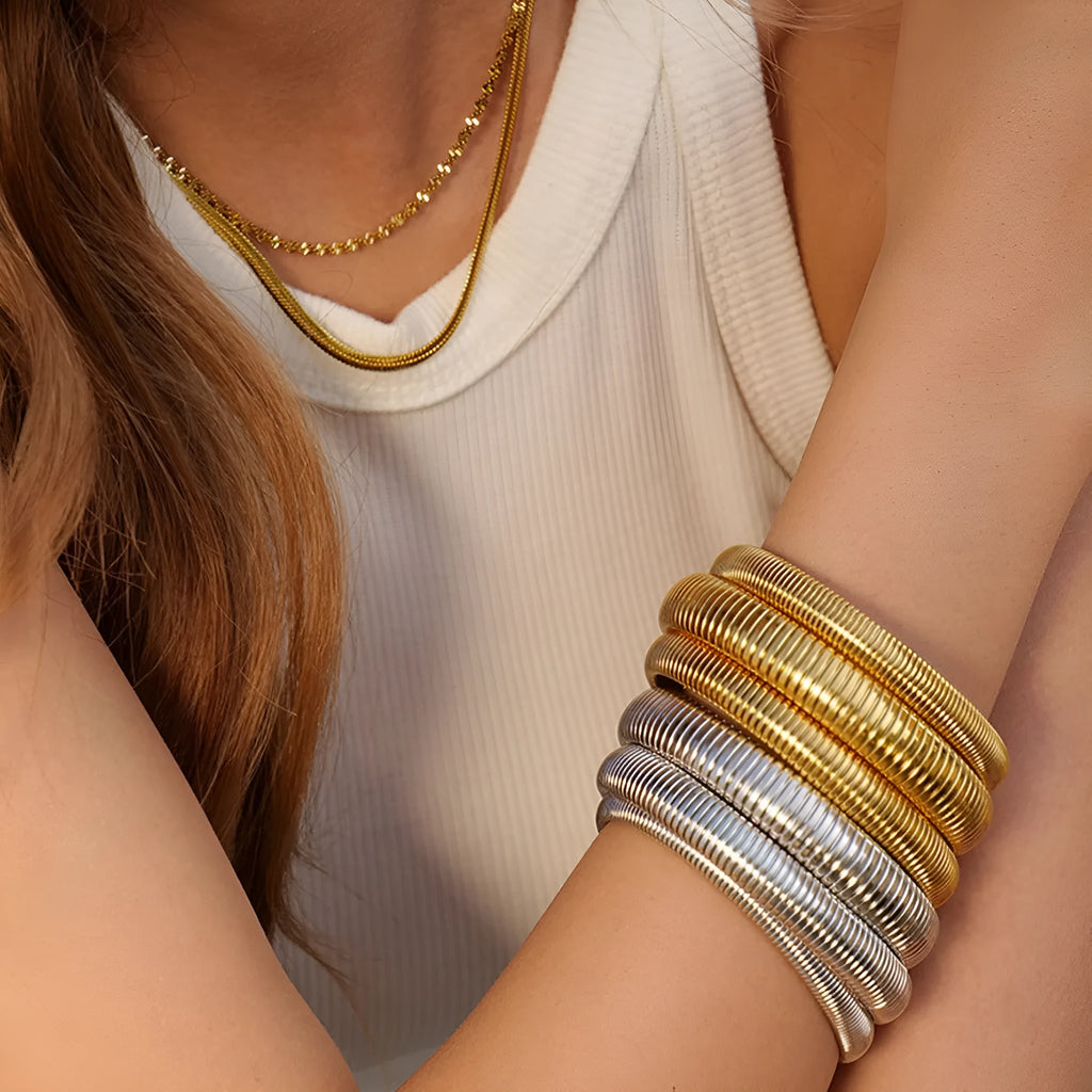 Women's titanium steel elastic bracelet showing vertical stripe ring pattern in gold finish