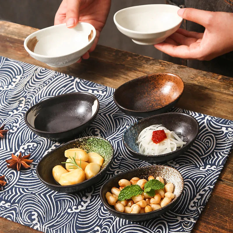 Oval Japanese ceramic sauce dipping bowl with underglaze decorative pattern on simple white background